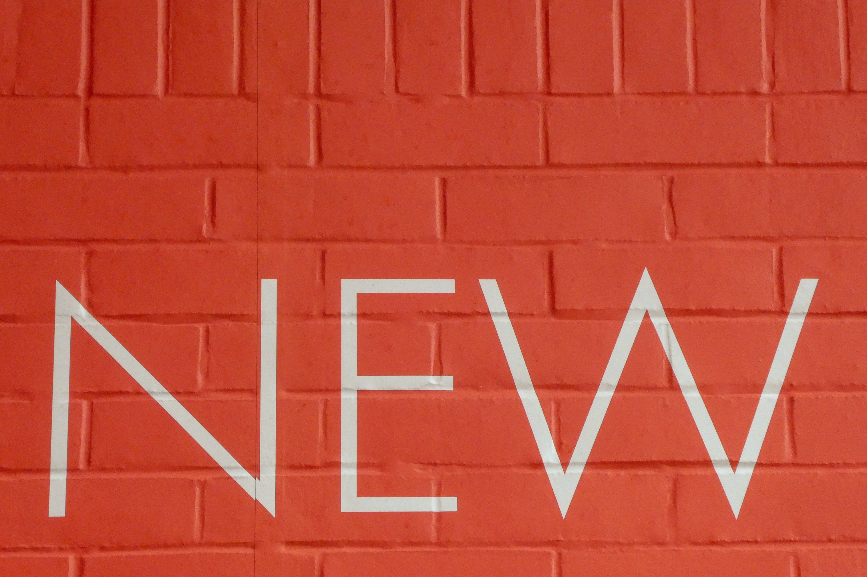 NEW written on an orange brick wall