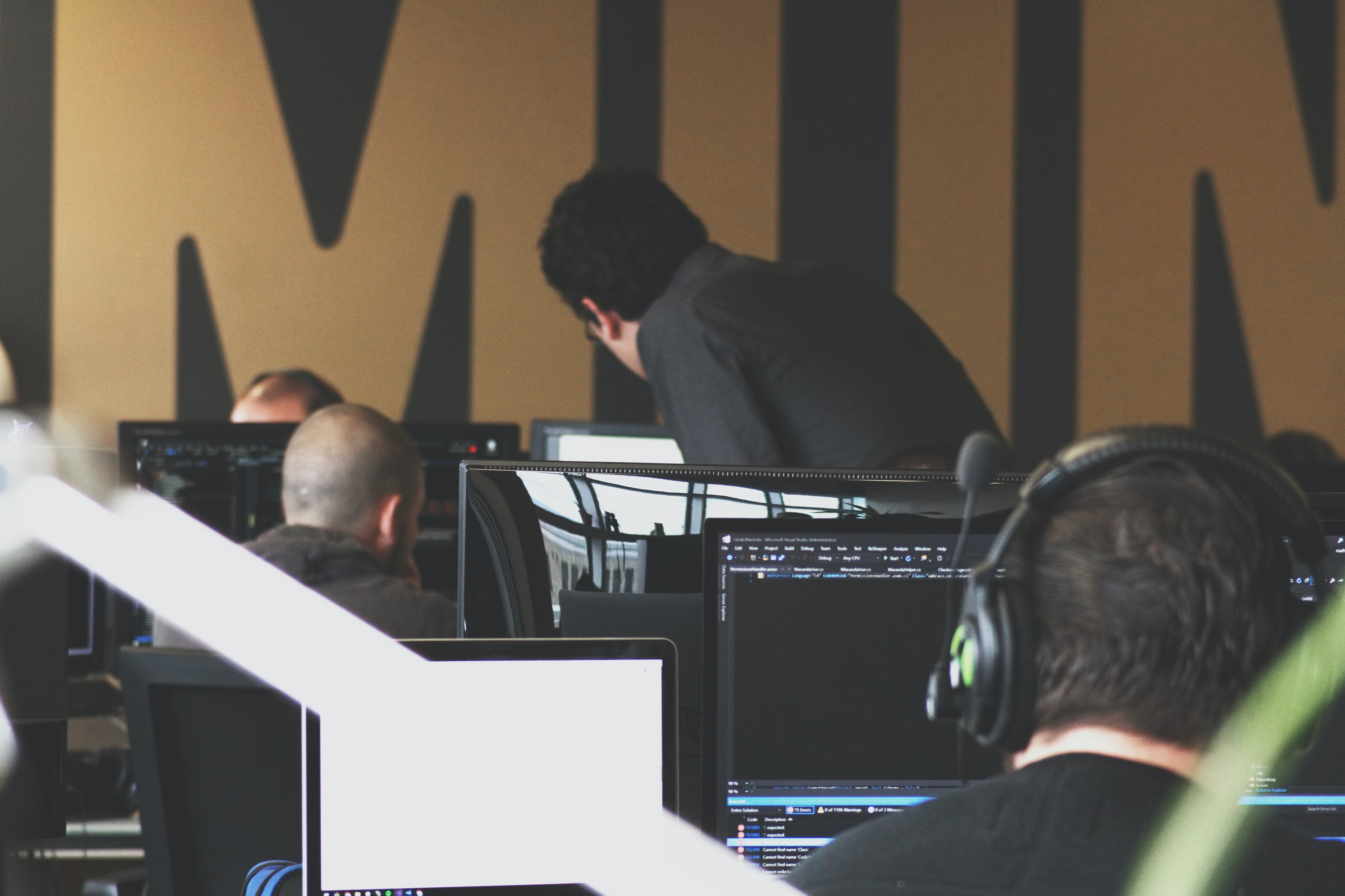 team using computers talking to manager