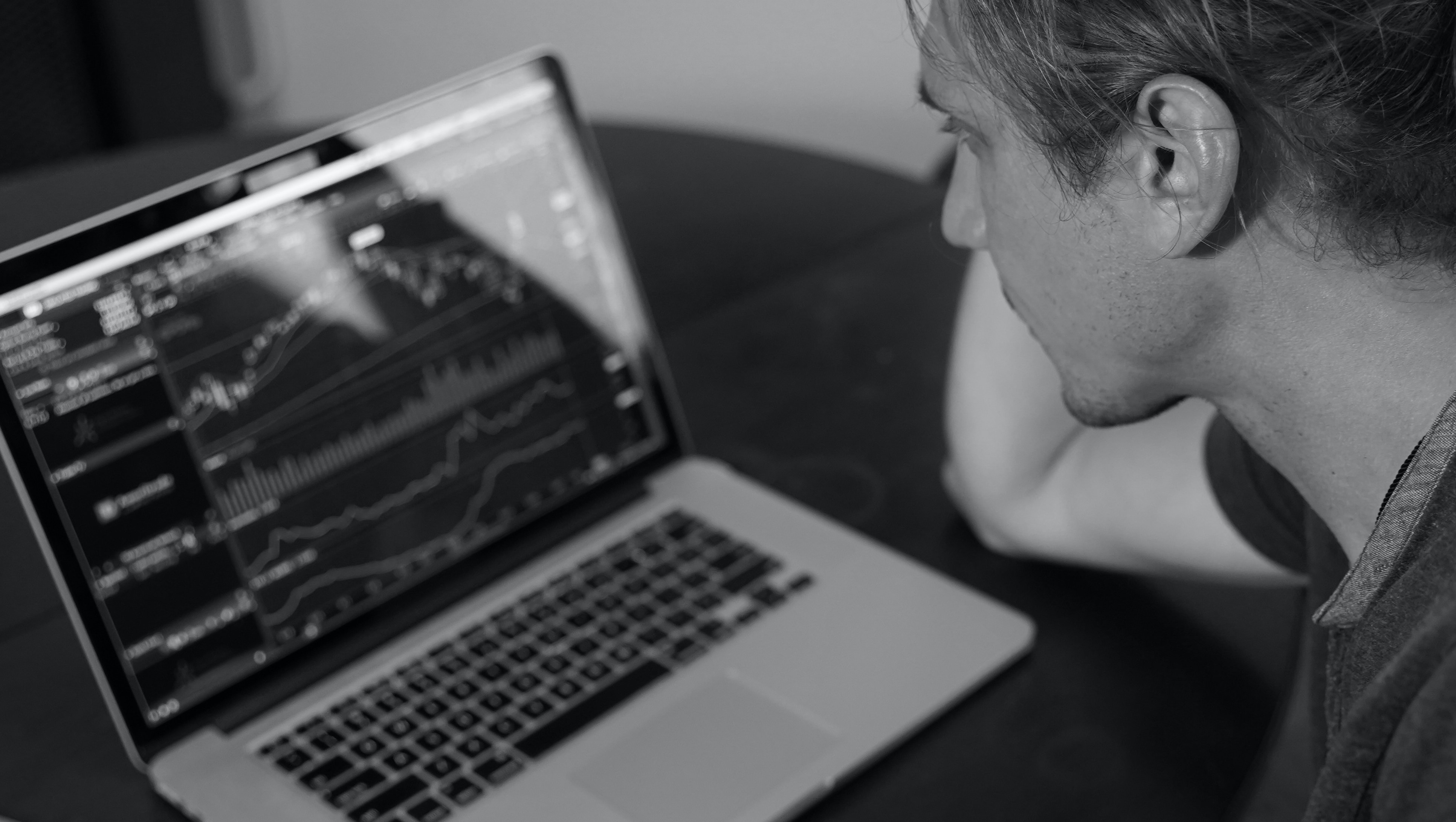man studying charts on a laptop