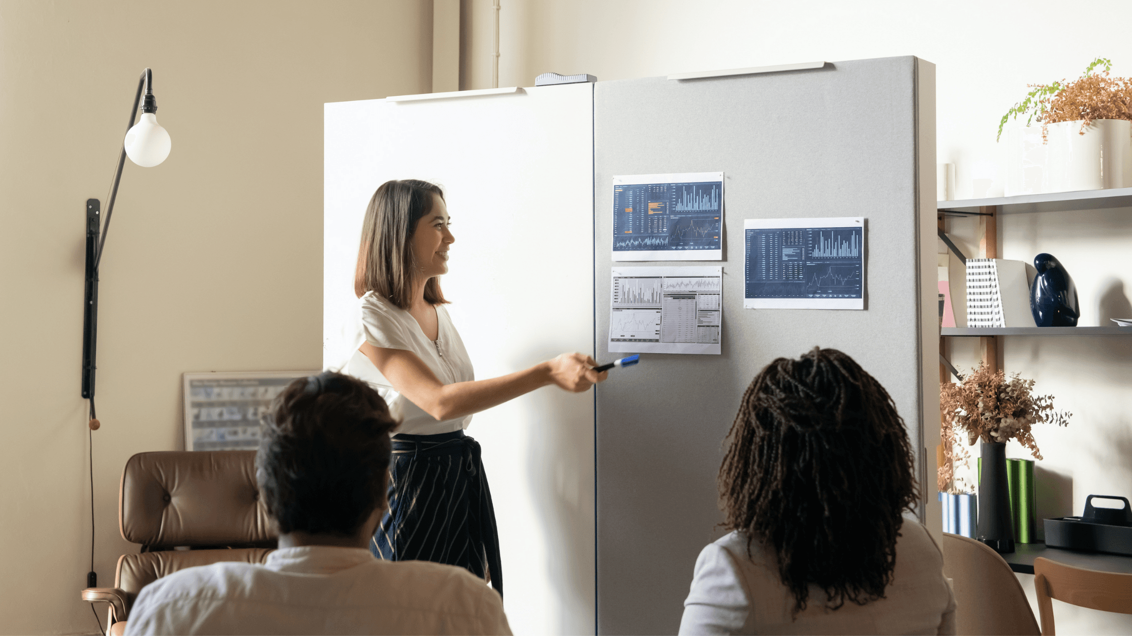 female employee presenting charts to her team