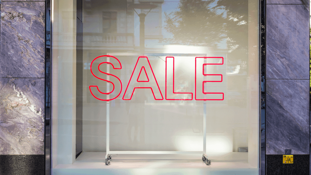 SALE on the front of a store window glass