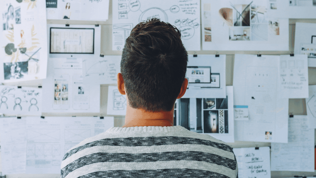 man looking at research board